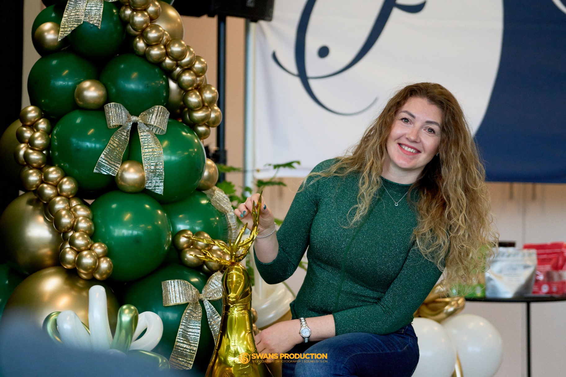 Decorated venue with green and gold balloon Christmas tree at the charity event in Calgary