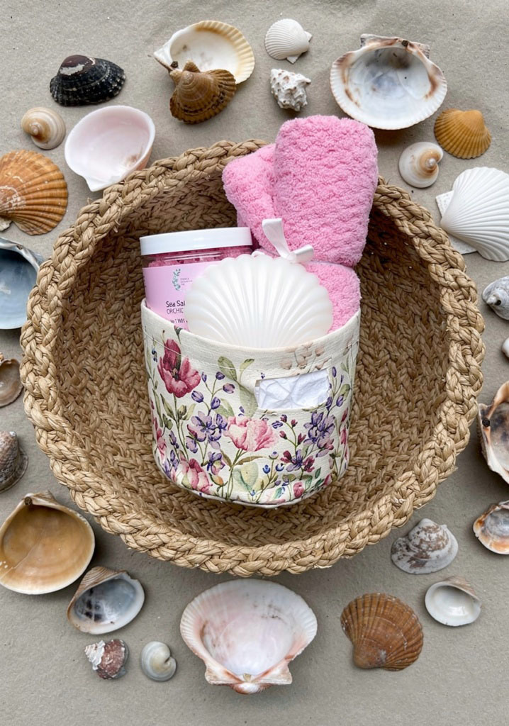 Overhead view of the gift basket in a woven tray surrounded by seashells